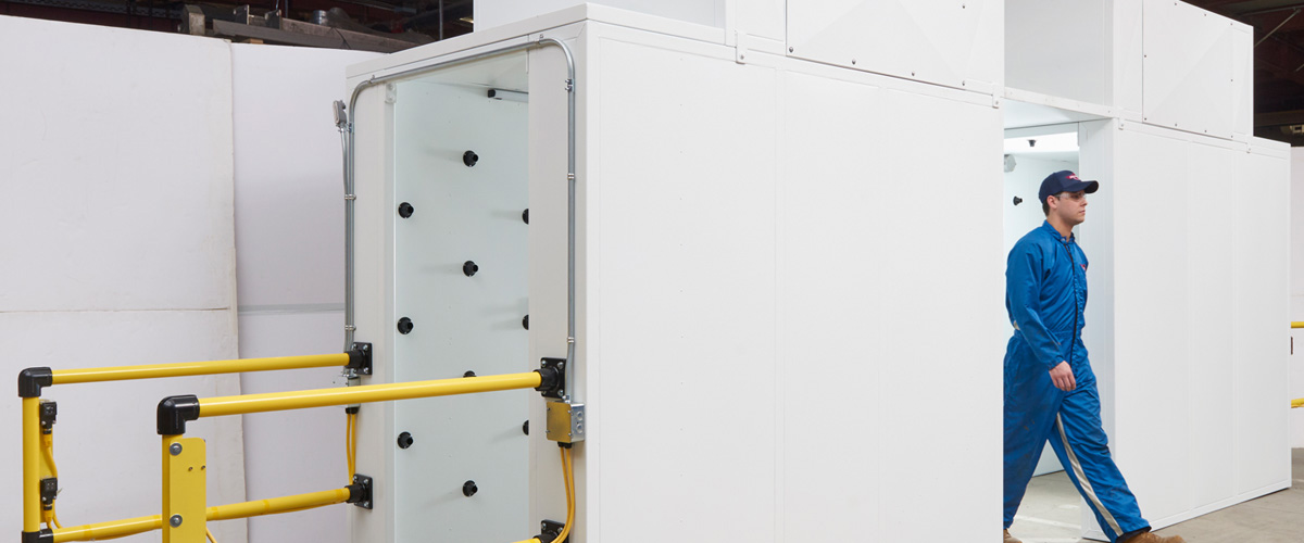 Worker entering industrial air shower system for cleanroom contamination control